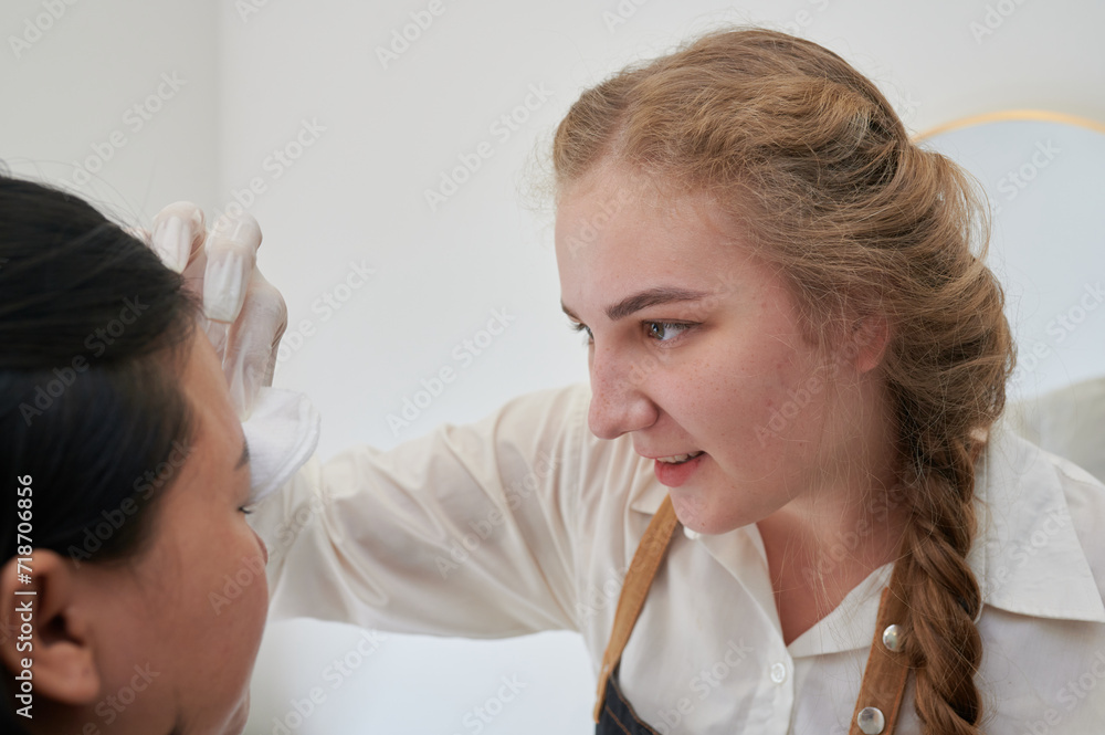 Young Asian woman undergoing eyebrow correction procedure in beauty salon, closeup Young Asian woman undergoing eyebrow correction procedure in beauty salon, closeup