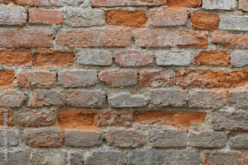 Strongly decayed wet brick wall with damaged bricks
