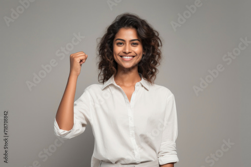 Young smiling woman showing a cheering gesture with closed fist photo
