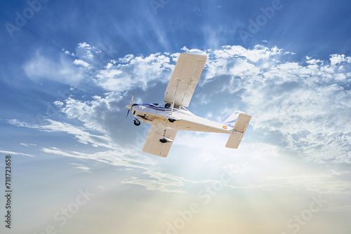 Single engine ultralight plane flying in the blue sky with white clouds	