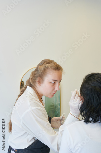 macro photography of the model's hairs the master combs the eyebrow hairs with a  brush after the procedure long-term styling and lamination