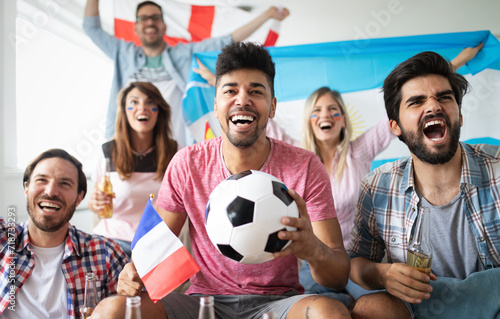 Young group of friends watching sport on television