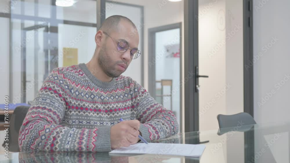 Young Hispanic Man Working on Documents Young Hispanic Man Working on Documents
