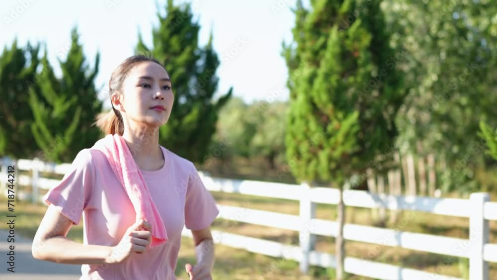Happy thin woman wearing sports clothes jogging at the park at sunrise Beautiful young Asian woman in exercise clothes running outdoors. Morning exercise The concept of a healthy and active lifestyle Happy thin woman wearing sports clothes jogging at the park at sunrise Beautiful young Asian woman in exercise clothes running outdoors. Morning exercise The concept of a healthy and active lifestyle