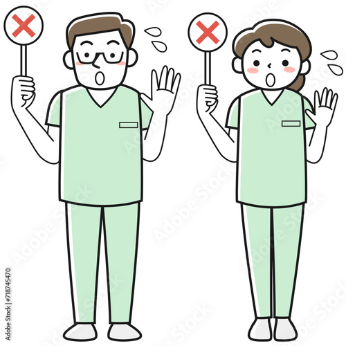 バツの札を持って制止する医療従事者の男女