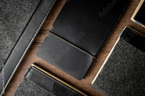Handmade black wallet made of genuine leather on a wooden background. Close-up, top view. photo
