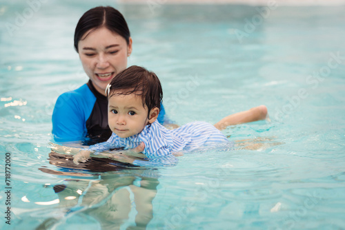 mother teaching her daughter swimming in pool © geargodz