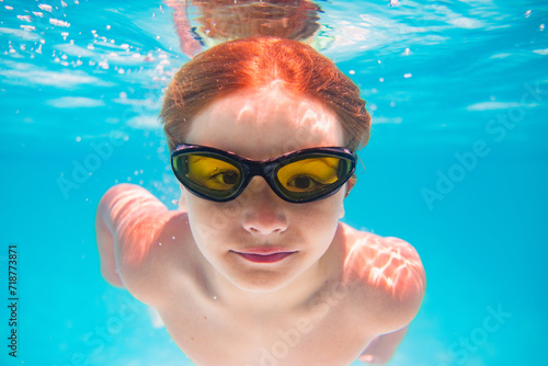 Child playing in swimming pool. Kids holidays and vacation concept. Summer kid play in swimming pool. Little child boy in pool underwater. Kids swim in pool on summer vacation.