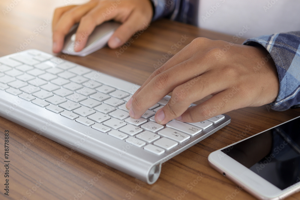 Close up of male hand using wireless keyboard and mouse in office desk. Casual working concept Close up of male hand using wireless keyboard and mouse in office desk. Casual working concept