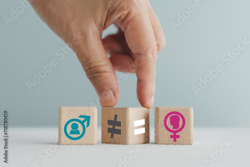 Foto hand flipped unequal  to equal   sign on wooden cubes  between male and female sign