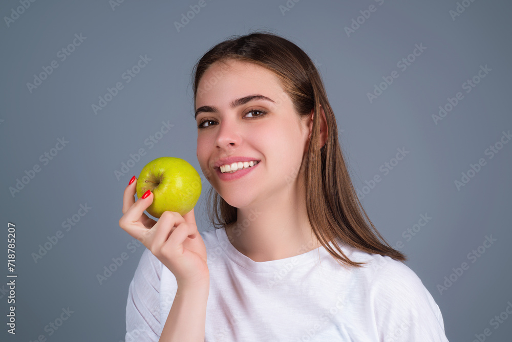Stomatology concept. Woman with perfect smile holding apple on studio isolated background. Woman eat green apple. Portrait of young beautiful happy smiling girl with green apples. Healthy diet food. Stomatology concept. Woman with perfect smile holding apple on studio isolated background. Woman eat green apple. Portrait of young beautiful happy smiling girl with green apples. Healthy diet food.