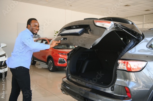 Happy Car Buyer  New Car Owner Concept. Portrait Of Excited Young African American Guy In Dealership Showroom