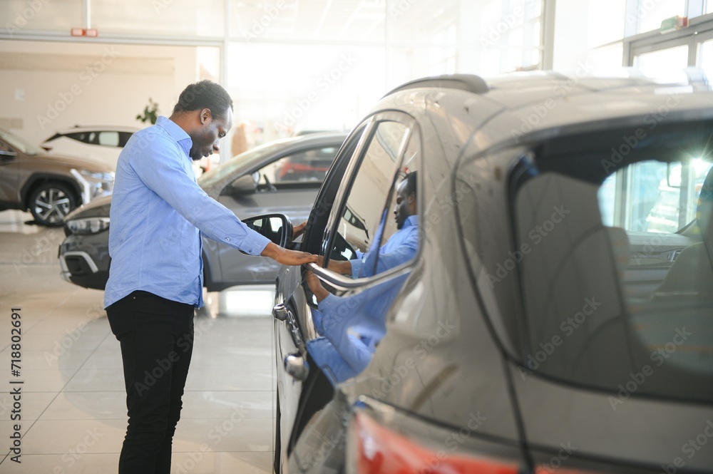 Car Buyer. Black Guy Choosing New Automobile In Dealership Store Car Buyer. Black Guy Choosing New Automobile In Dealership Store