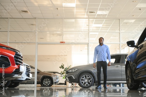 Car Buyer. Black Guy Choosing New Automobile In Dealership Store