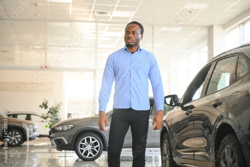 Handsome African man choosing a new car at the dealership © Serhii