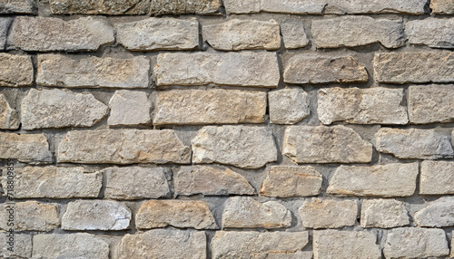 wall of stones as a texture for background; gray beige stone bricks close-up