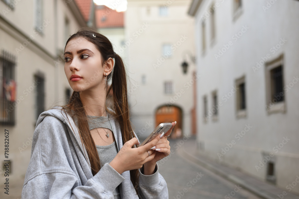 Fototapeta premium Beautiful girl with a phone in the city