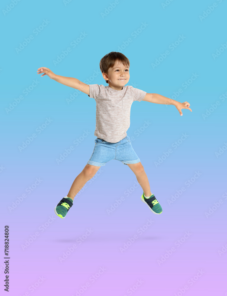 Happy boy jumping on color gradient background Happy boy jumping on color gradient background
