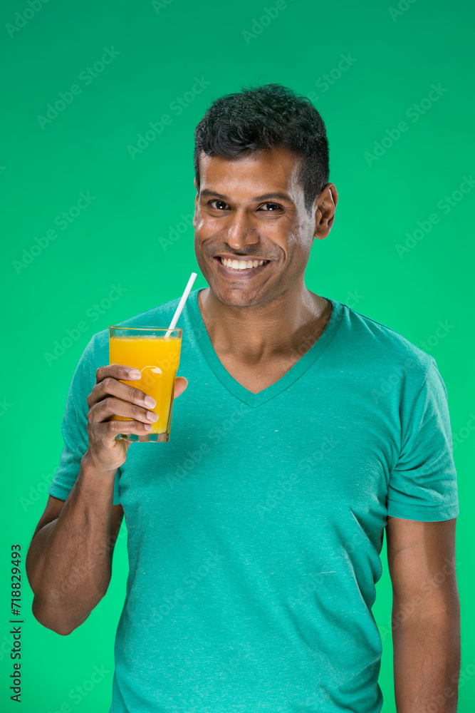 Happy Indian man drinking orange juice Happy Indian man drinking orange juice