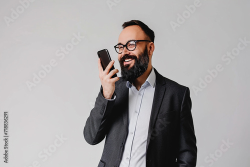 portrait of happy young man wearing back shirt with beard talking on phone on isolated white background