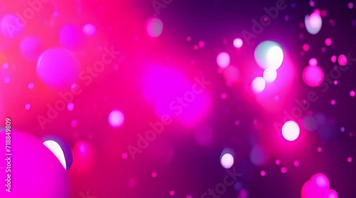 Soft pink, teal and purple particles flying in air creating bokeh