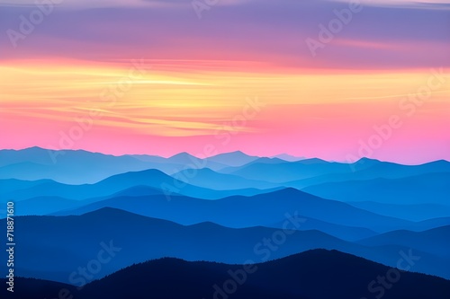 silhouette of dark mountains at dawn. dark blue mountains in the foreground fade into an orange sky