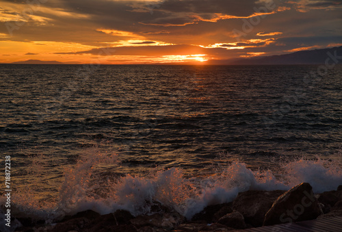 Sea sunset with waves crashing on the rocks. 