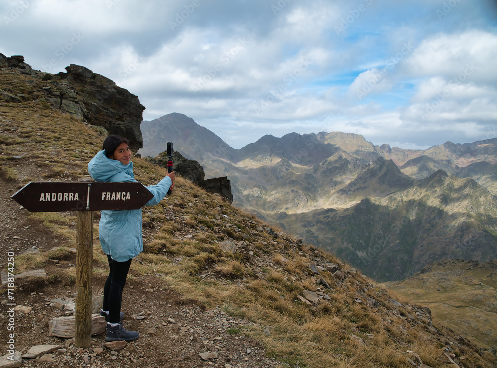Fototapeta premium Girl hiker recording a video in Tristaina viewpoint in andorra, in high mountain in the andorran and french Pyrenees.