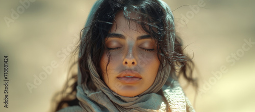 Biblical character. Close up portrait of a young woman in a veil with closed eyes. photo