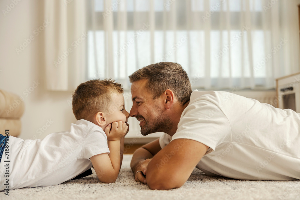A father and son rubbing their noses and bonding at home. A father and son rubbing their noses and bonding at home.