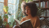 Engrossed Young Woman Reading a Book in a Sunny Room Surrounded by Houseplants