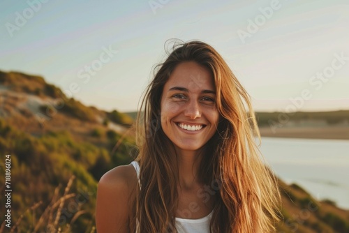 A smiling woman standing in the wall background Radiant young woman laughing, with sunlight