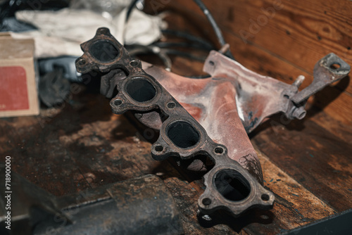 Fototapeta Naklejka Na Ścianę i Meble -  A close-up of a removed rusty car exhaust manifold, awaiting refurbishment.