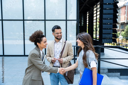 Foto Group of young business people, job candidates standing in front of the office building waiting to be called to meeting with the employer