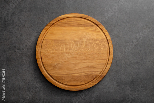 Empty wood round cutting board on black background