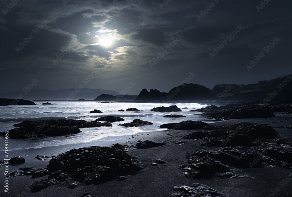 a full moon set at night on the coast
