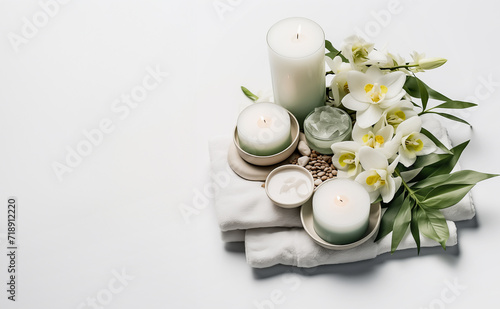 Wellness setting with towel, candles and orvhid flowers at white background. Spa and relaxing concept