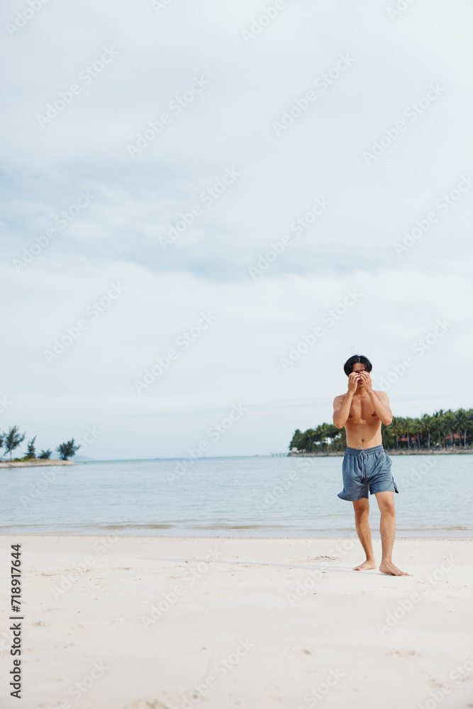 Muscular Asian Athlete Enjoying Outdoor Cardio Training on the Beach at Sunset