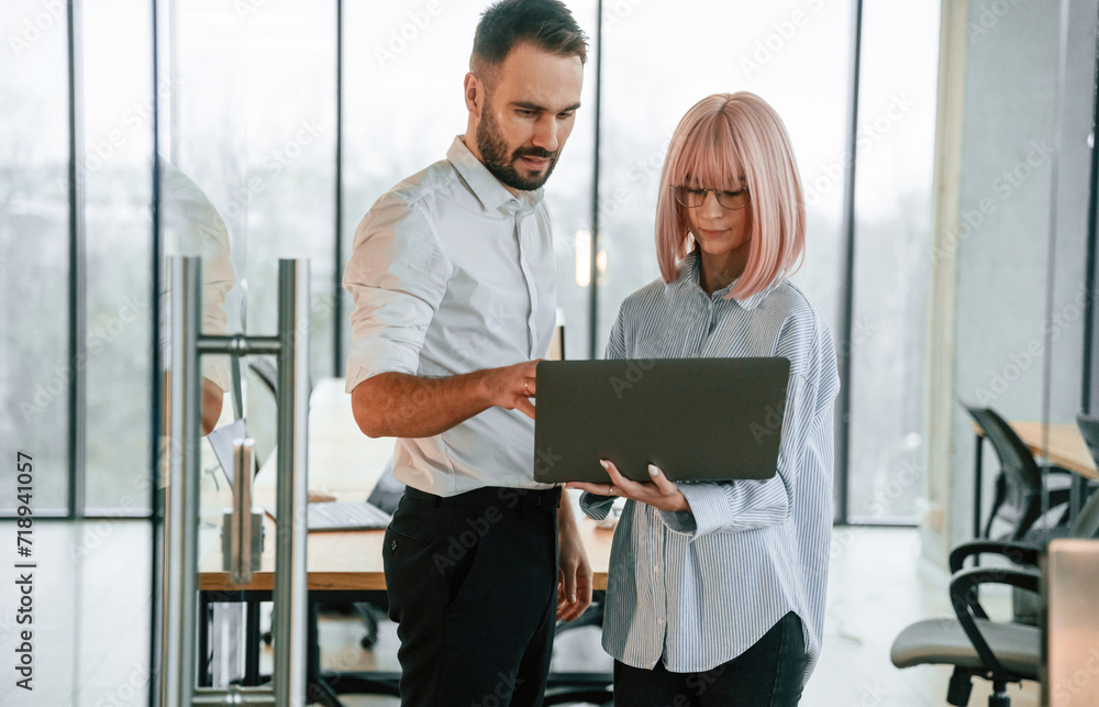 Fototapeta premium Using laptop. Man and woman are working in the office together