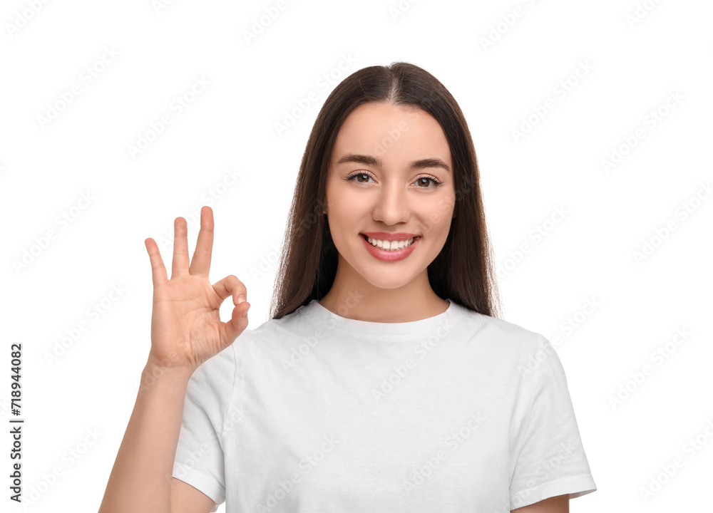 Young woman with clean teeth smiling and showing ok gesture on white background Young woman with clean teeth smiling and showing ok gesture on white background