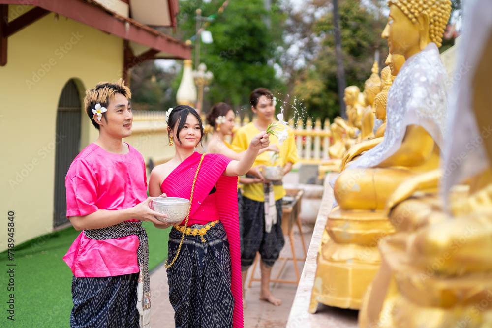 A couple bathes a Buddha statue during the Songkran festival in Thailand.