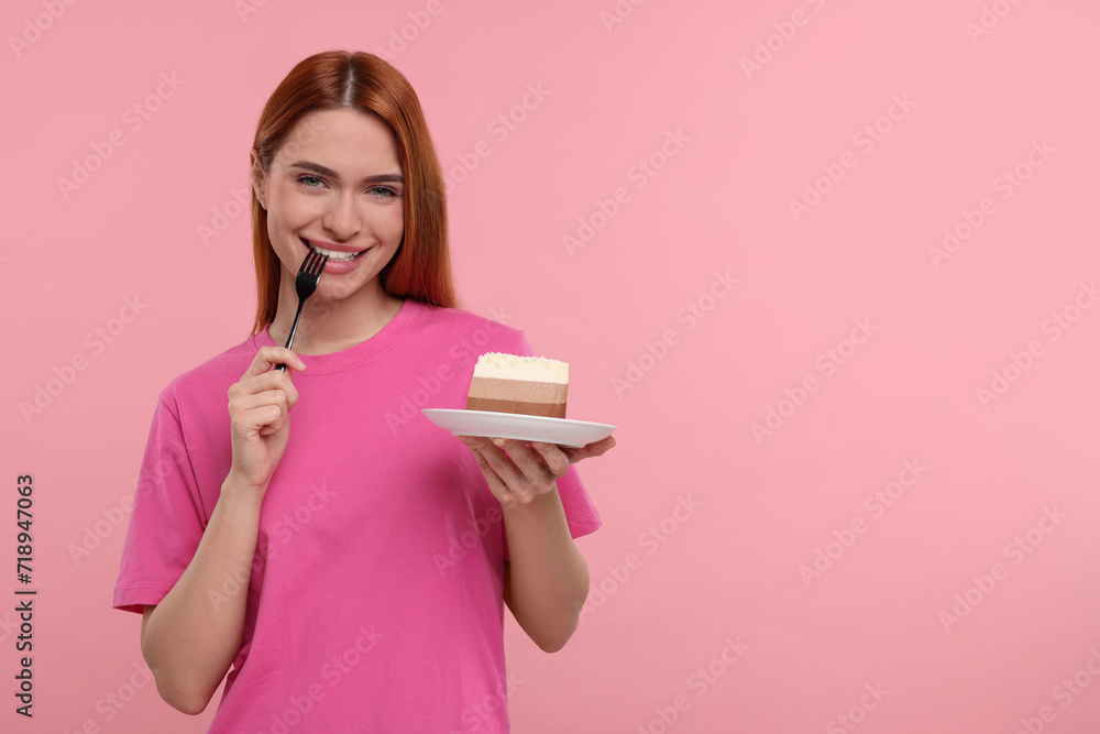 Young woman eating piece of tasty cake on pink background, space for text Young woman eating piece of tasty cake on pink background, space for text