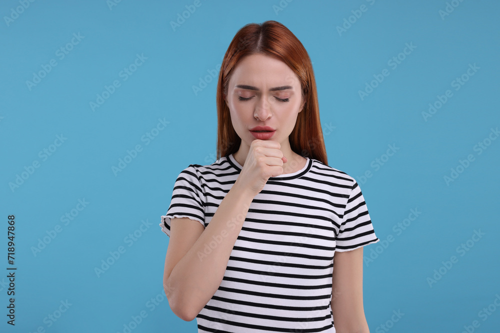Woman coughing on light blue background. Cold symptoms Woman coughing on light blue background. Cold symptoms
