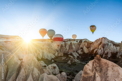 Amazing Cappadocia rocky landscape and balloons at sunrise, view of the valley and canyons.