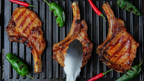 Lamb chops pork with bone on grill. Turn meat. Top view. Slow motion. Loin on ribs
