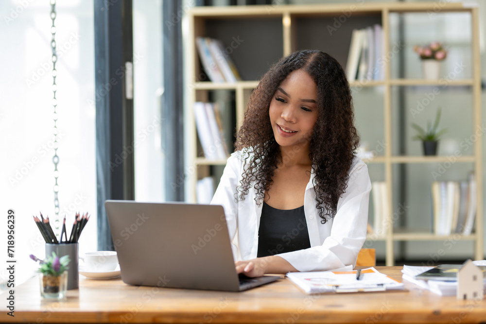 Black businesswoman sitting in front of laptop in office focused on busy work. Black businesswoman sitting in front of laptop in office focused on busy work.