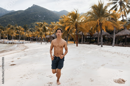 Muscular Asian Man Enjoying Beach Run  Embracing Fitness Lifestyle in the Sand