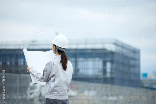 建設現場と作業服を着た女性