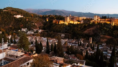 Establishing shot shows the Alhambra Palace illuminated against the night sky, overlooking the Old Quarter of Granada, Andalucia, Spain