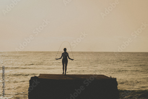 girl jumping rope in the beach, chica saltando la comba en la playa al amanecer photo